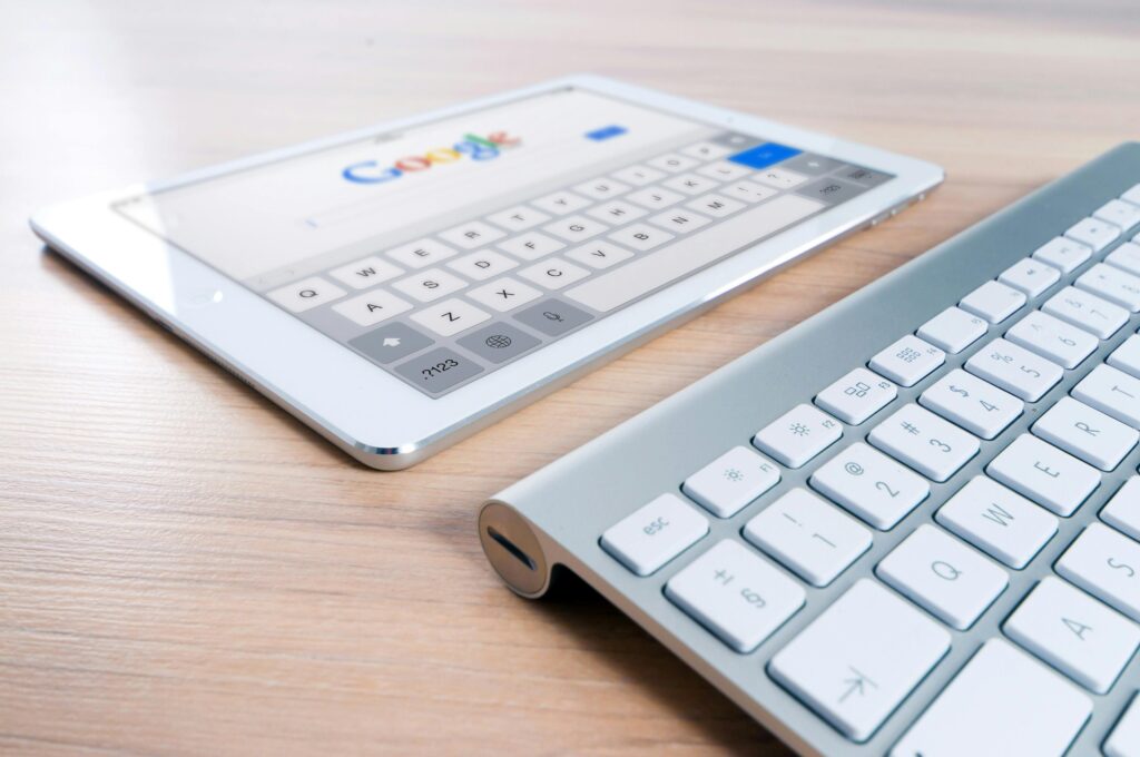 pexels-photo-270669-270669 A modern tablet displaying a search engine logo next to a wireless keyboard on a wooden desk.